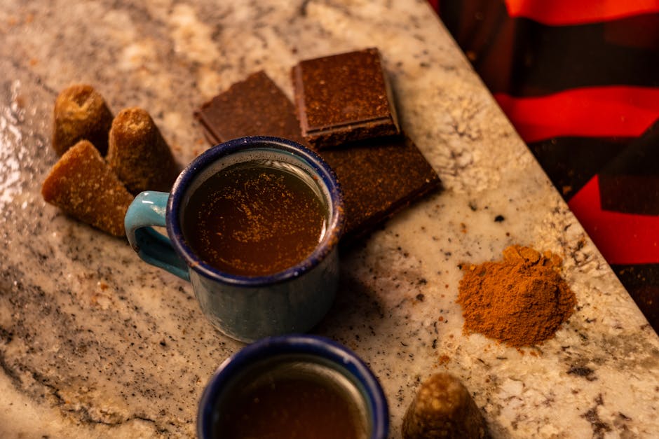 casarabe – Traditioneller mexikanischer Café de Olla mit Zimt und Piloncillo auf einer Marmorarbeitsplatte.