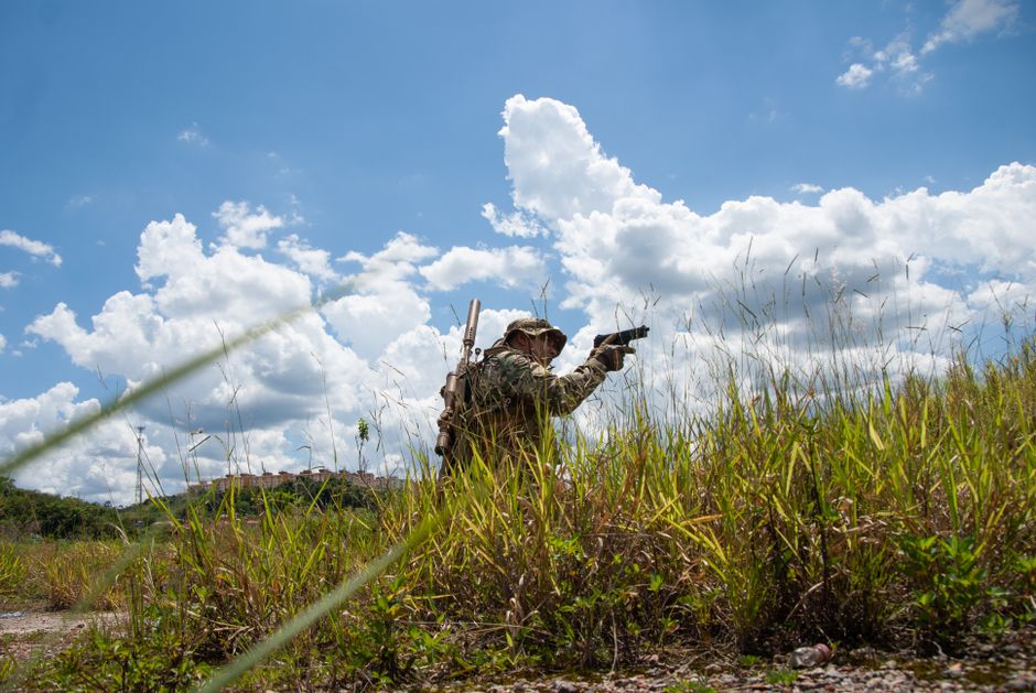 Munduruku: Brasiliens Tapajós-Krieger im Kampf um Land – Soldat in Tarnkleidung navigiert über ein grasbewachsenes Feld un…
