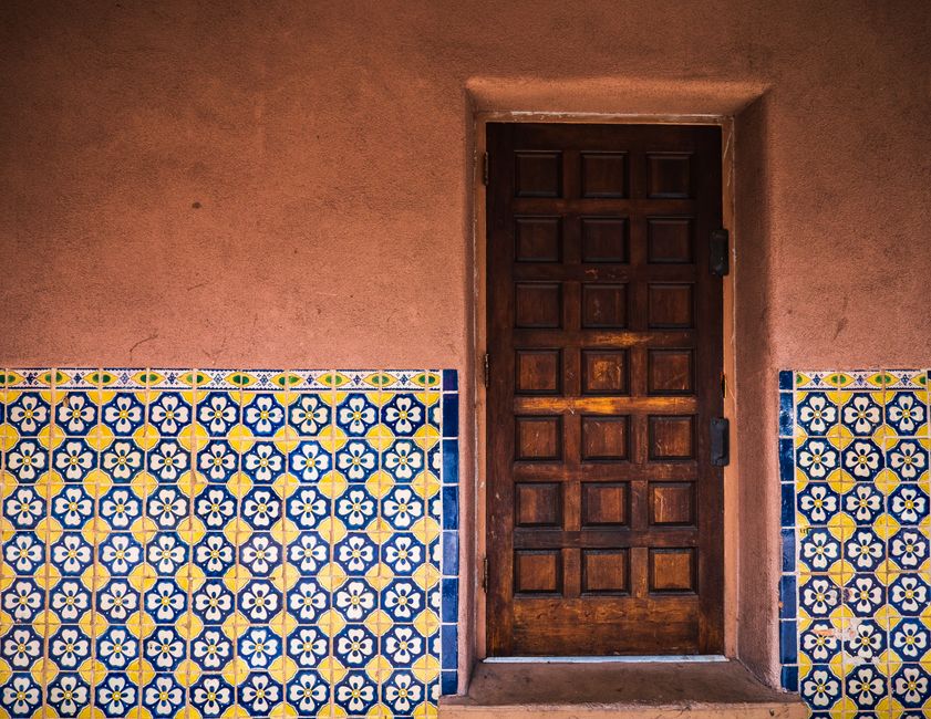Pueblo Tour Santa Fe: Ein umfassender Guide zu New Mexicos Kultur – Rustikale Holztür mit lebendigen gemusterten Fliesen i…