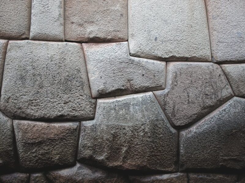 Intihuatana: Der Sonnenstein der Inka – Detailansicht einer alten Inka-Steinmauer in Cusco, die präzise Steinmetzarbeiten …