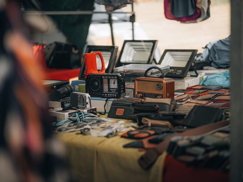 Kuhikugu: Heckenbergers Funde im Xingu-Gebiet – Eine Tischausstellung mit Vintage-Radios, Gadgets und Lederwaren auf einem…