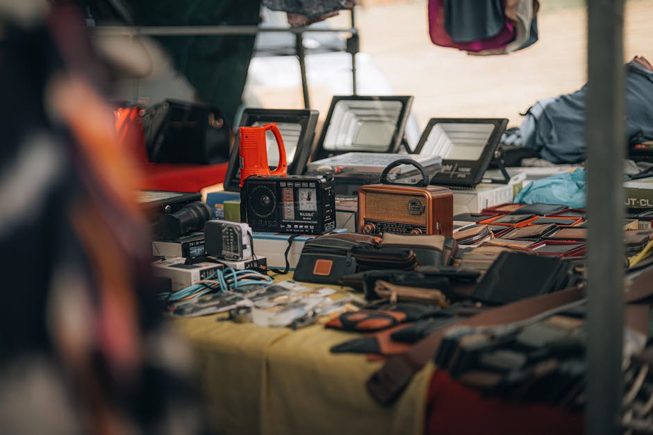 Kuhikugu: Heckenbergers Funde im Xingu-Gebiet – Eine Tischausstellung mit Vintage-Radios, Gadgets und Lederwaren auf einem…