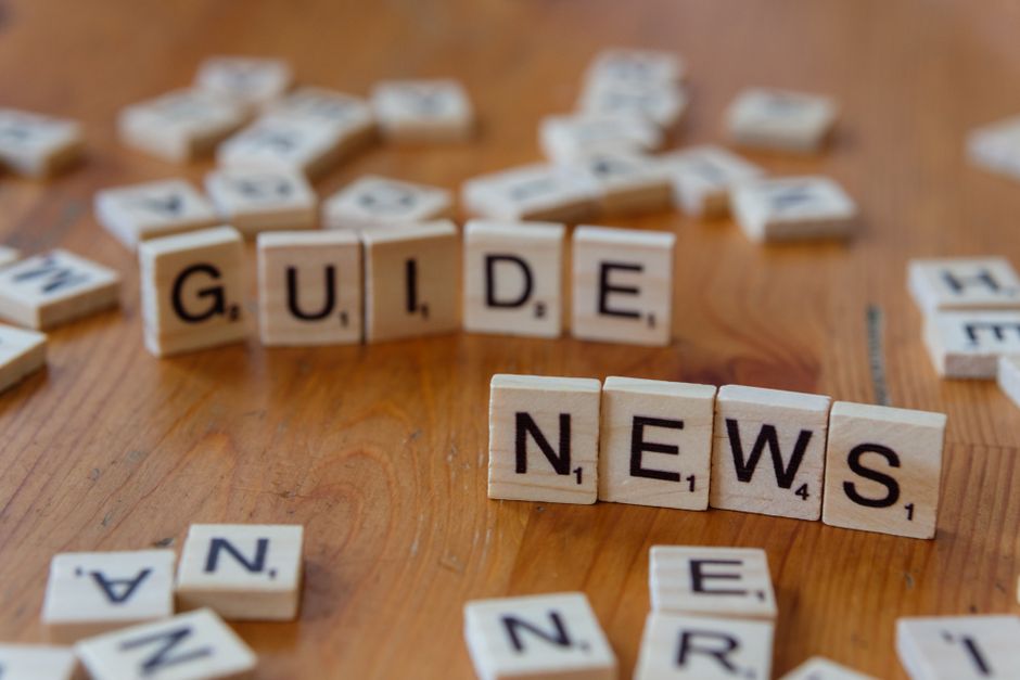 Gefundene Codices: Aktuelle Forschung und Herausforderungen – Nahaufnahme von Scrabble-Steinen, die „Guide“ und „News“ auf…