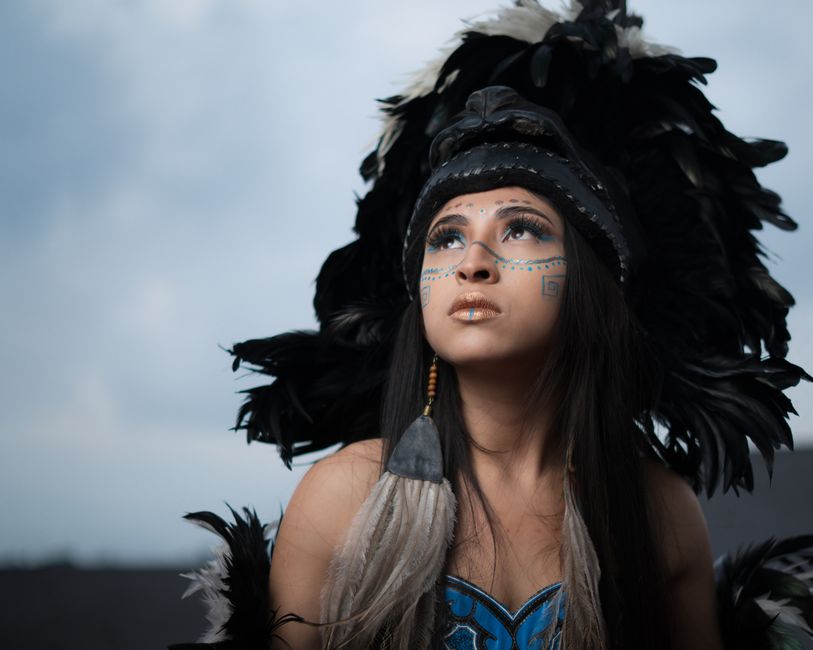 Kim TallBear: Indigene DNA-Kritik und Beziehungsforschung – Frau mit traditionellem Federschmuck und Gesichtsbemalung, die…
