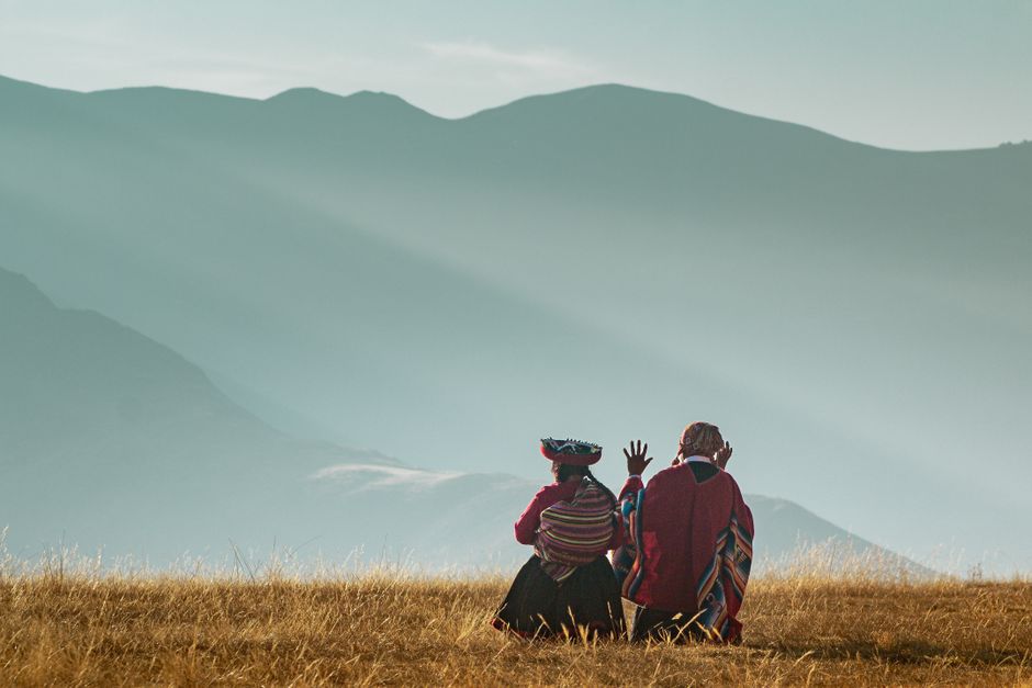 Quechua Sprecher: Vitalität und Verbreitung im Andenraum – Zwei Menschen in traditioneller Andenkleidung sitzen in den Ber…