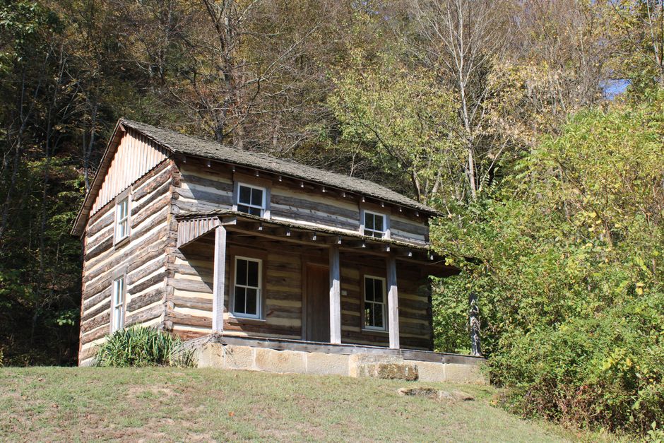 Adena-Kultur: Frühe Mound-Builders im Ohio Valley – Rustikale Blockhütte inmitten herbstlicher Bäume in Ohio, USA. Perfekt…