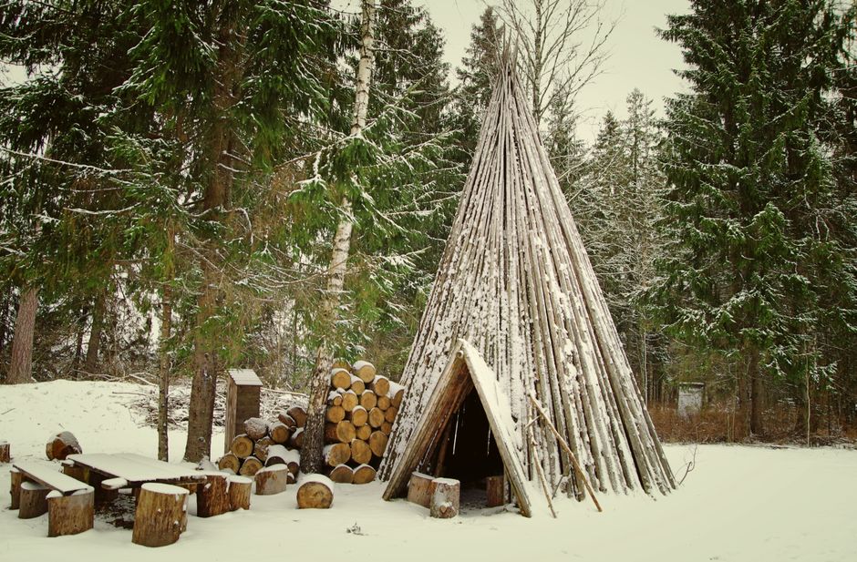 Tipi: Die traditionelle Wohnform der Plains-Völker Nordamerikas – Rustikales Tipi in einem verschneiten Wald, umgeben von …