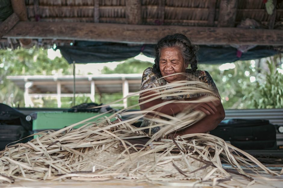 Yanomami: Lebensweise, Kultur und aktuelle Herausforderungen – Eine ältere Frau flechtet in der freien Natur von Kiribati …