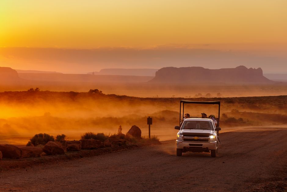 Navajo Nation Tour: Ihr Guide zu den Wundern des größten Reservats – Ein Fahrzeug fährt einen staubigen Weg im Monument Va…