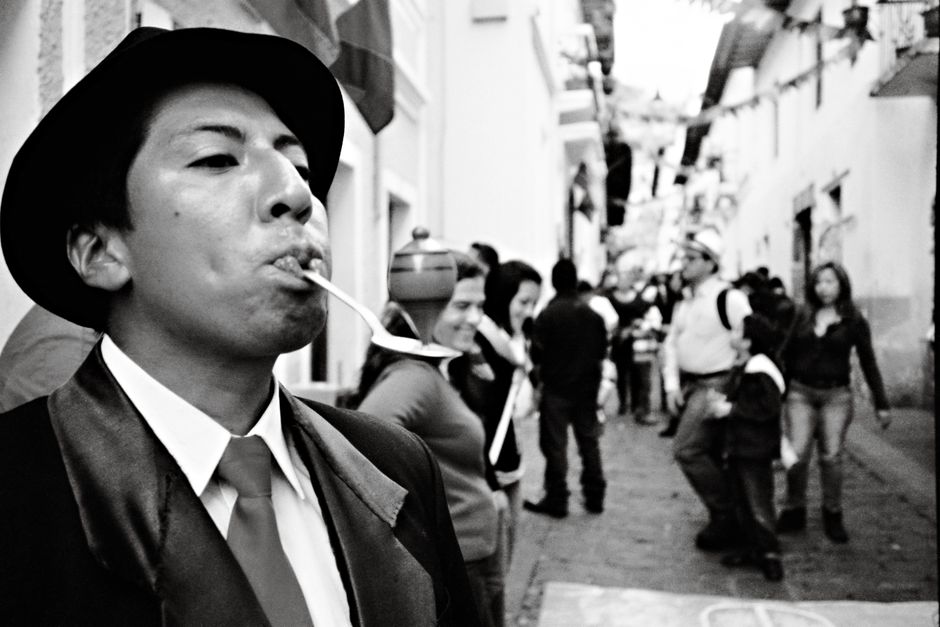 Quito Casa Alabado: Präkolumbianische Kunst in der Altstadt – Schwarz-Weiß-Foto eines Straßenkünstlers mit einem Hut in Qu…
