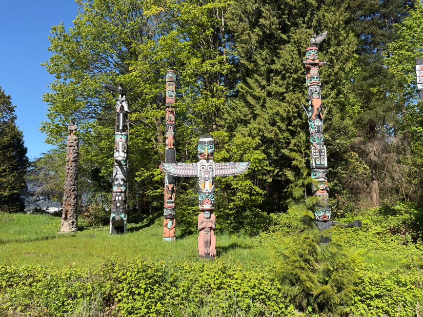 Totem Pfähle: Symbolik, Typen und die First Nations der Nordwestküste – Totempfähle in einem farbenprächtigen Wald, Stanle…